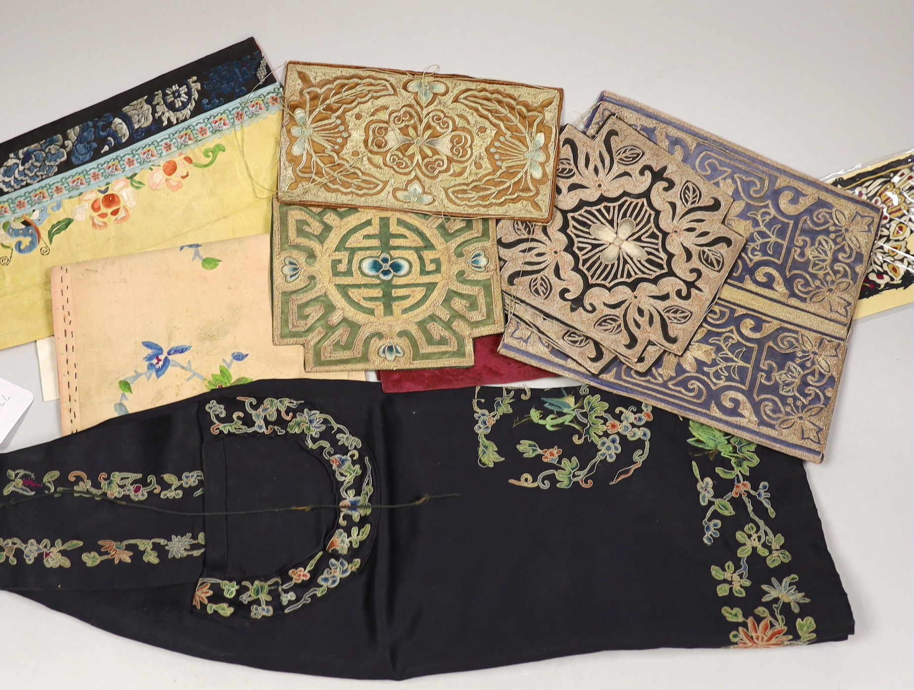 A collection of mixed Chinese polychrome and metallic thread embroidered panels, including a Chinese knot embroidered apron and blue embroidered panel, 19th/20th century